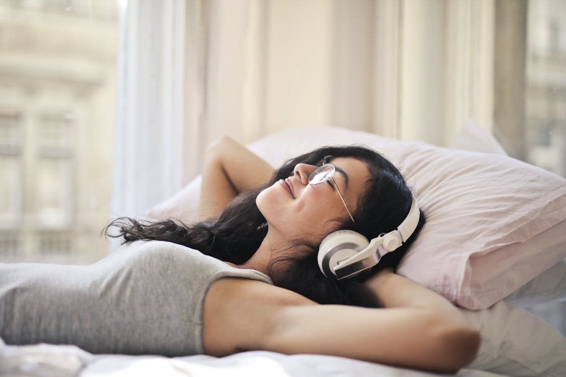 Free Woman in Gray Tank Top Lying on Bed Stock Photo