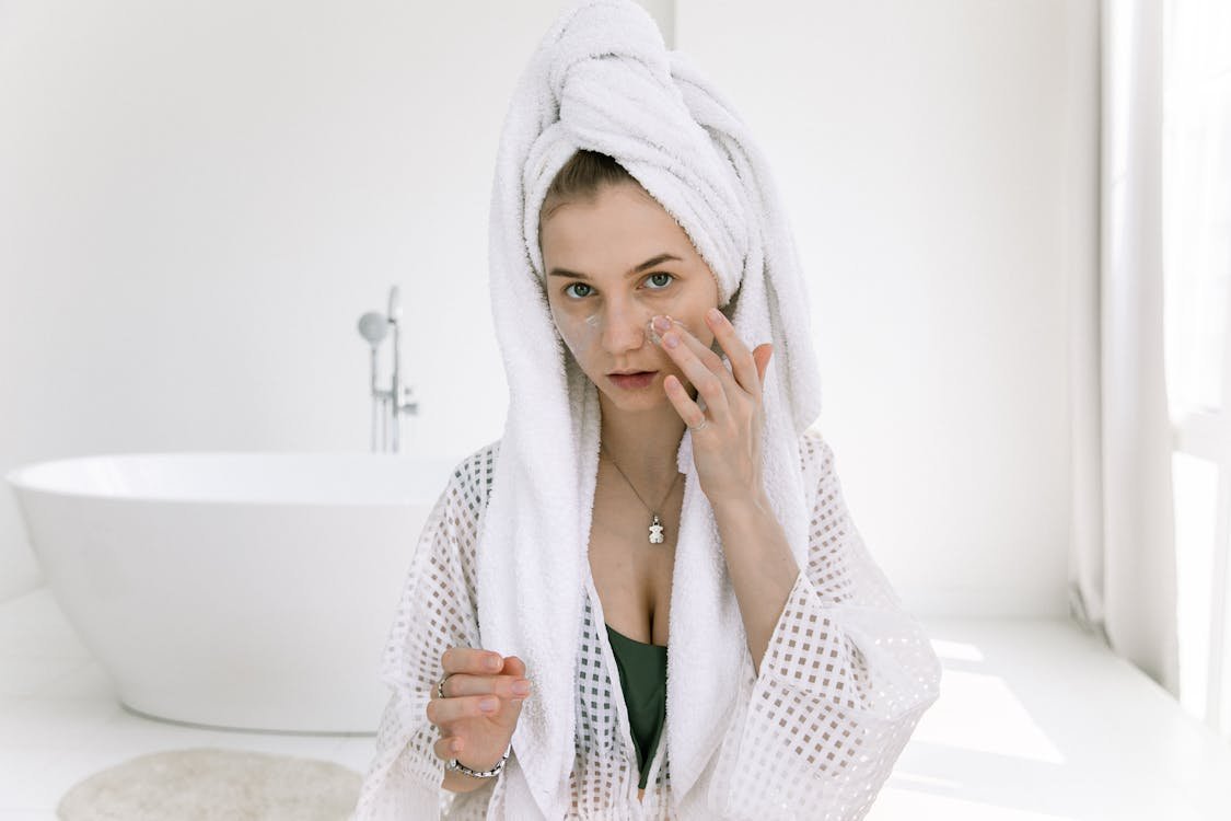 Free Photo Of Woman Applying Cosmetics On Her Face Stock Photo