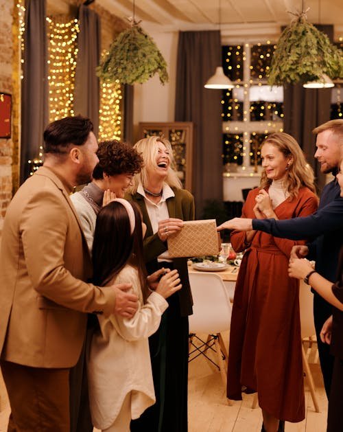 Free A cheerful group of friends celebrating together indoors during Christmas festivities. Stock Photo